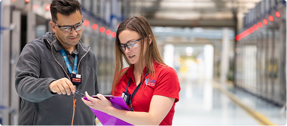 two people looking at a clipboard on site