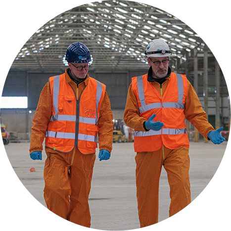 Two people in orange PPE walking